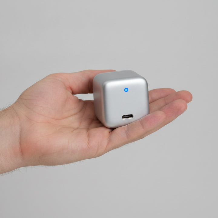 Hand håller kompakt USB-C snabbladdare för att visa storleken