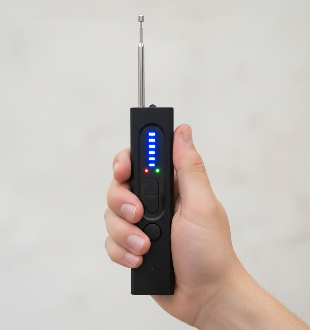 Hand håller RF-signaldetektor med blå LED-display
