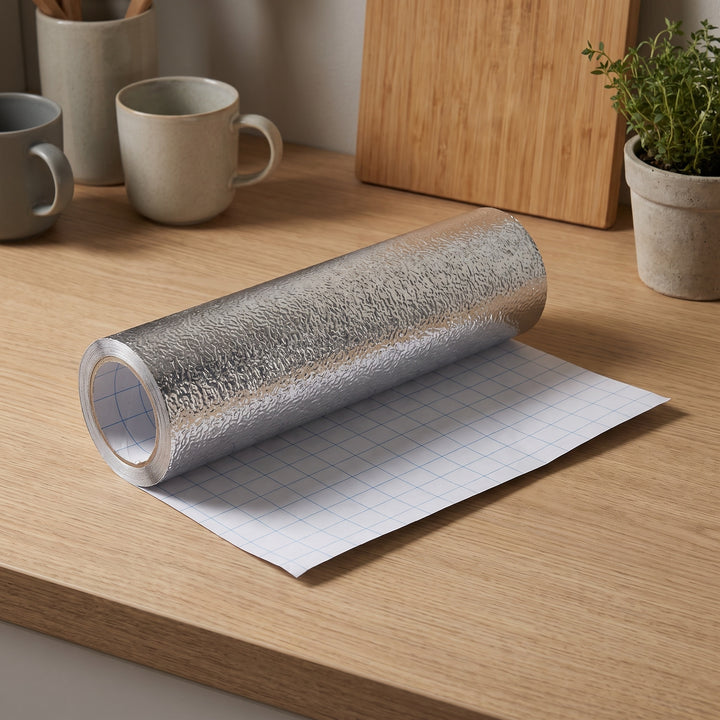 Silver aluminiumfolie rulle på träbänk i skandinaviskt kök