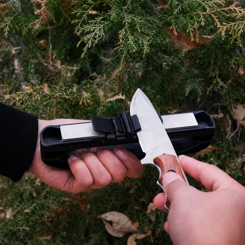 Två händer använder knivsliparen mot naturlig bakgrund