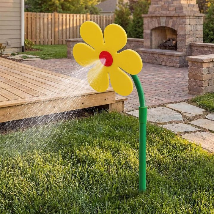 Gul blomsprinkler i trädgård med uteplatsmiljö