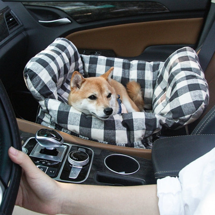 Hund i rutigt hundbilssäte i bil