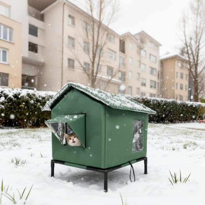 Upphöjt kattskydd i snö utomhus med katt inuti