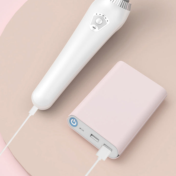 Vit vibrationsmassager ansluten till laddbank